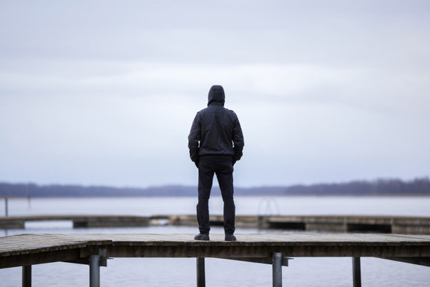 hooded figure on docks wondering about signs of heroin addiction