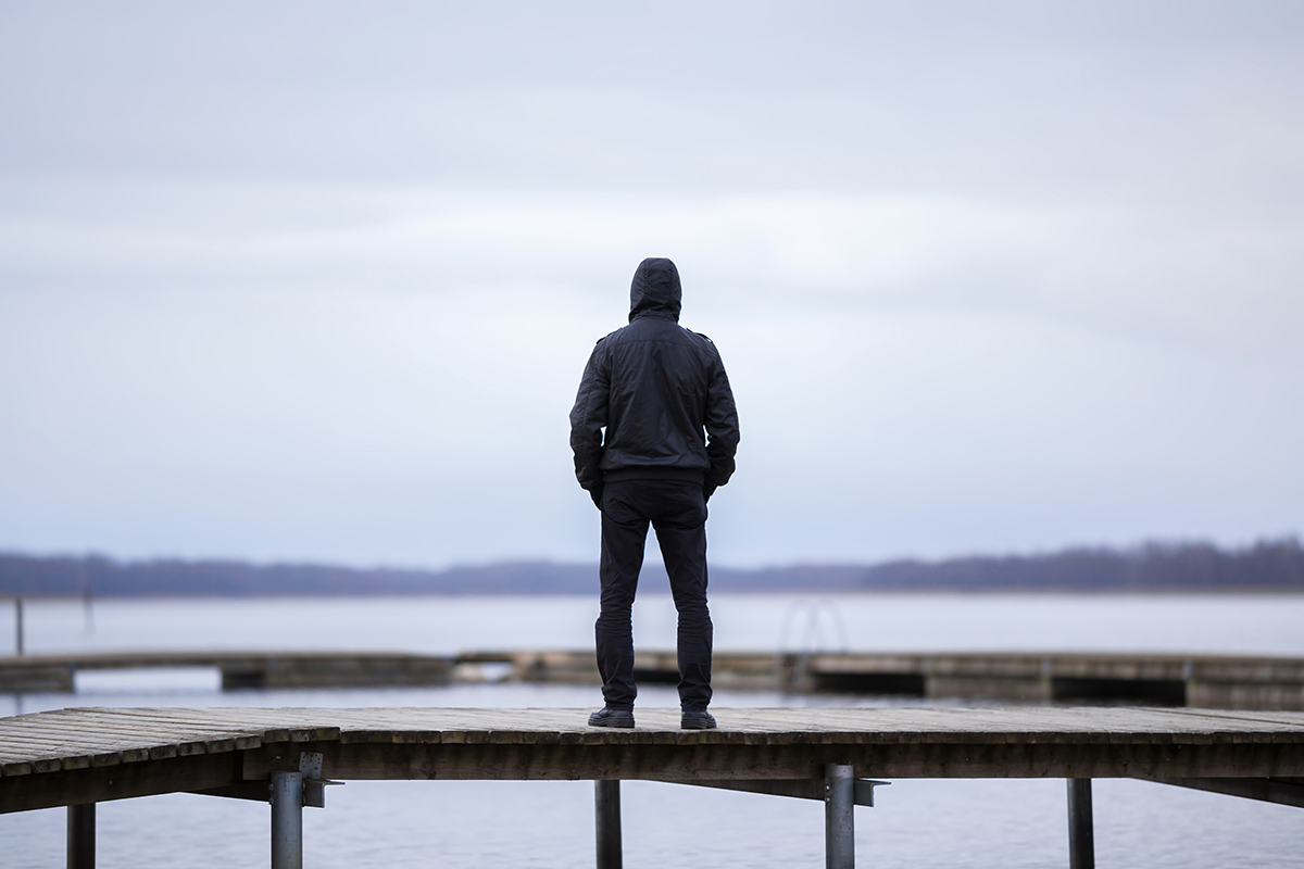 hooded figure on docks wondering about signs of heroin addiction